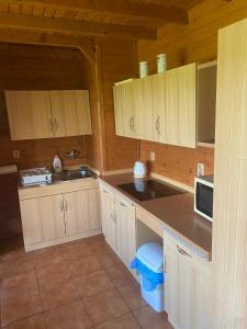 a kitchen with white cabinets and a counter top at Chaloupka u Náchoda pro rodiny s dětmi in Náchod +17 photos