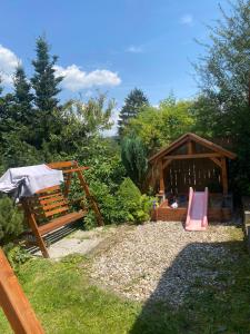 a playground with a bench and a wooden pavilion at Chaloupka u Náchoda pro rodiny s dětmi in Náchod