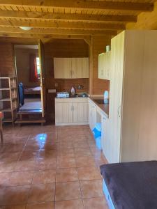 a kitchen with wooden cabinets and a large tile floor at Chaloupka u Náchoda pro rodiny s dětmi in Náchod