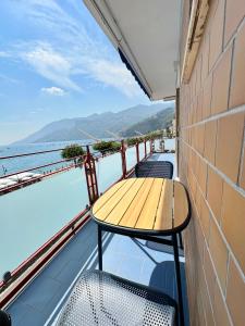 a table on a balcony with a view of the water at Blumare Amalfi Coast in Maiori