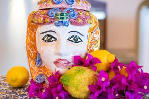 a statue of a woman with flowers and fruit at Baia Taormina - CDSHotels in Forza dʼAgro