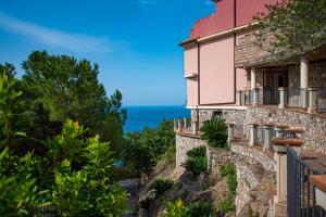 a building on a hill with the ocean in the background at Baia Taormina - CDSHotels in Forza dʼAgro