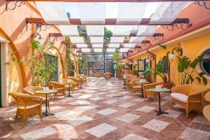 ein Restaurant mit Tischen und Stühlen und einer Decke in der Unterkunft Baia Taormina - CDSHotels in Forza dʼAgro