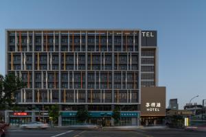 Un edificio alto con un cartel delante. en In Joy Hotel, en Taichung