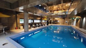 a large swimming pool with blue water in a building at Grim Resort in Jeju