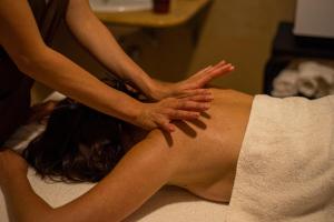 a woman getting a massage from a therapist at Baia Taormina - CDSHotels in Forza dʼAgro