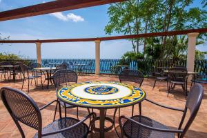 a patio with tables and chairs and a table with a plate on it at Baia Taormina - CDSHotels in Forza dʼAgro