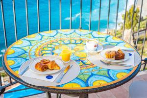 a table with two plates of food and a cup of coffee at Baia Taormina - CDSHotels in Forza dʼAgro