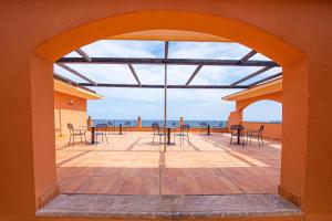 a patio with tables and chairs and the ocean at Baia Taormina - CDSHotels in Forza dʼAgro