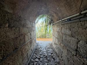 an alley way with a stone wall and a tunnel at Baia Taormina - CDSHotels in Forza dʼAgro