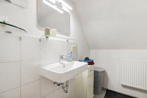 a bathroom with a sink and a mirror at Ferienhaus Reetkate Breklum in Breklum +23 photos