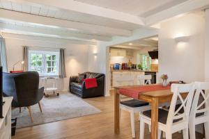 BreklumにあるFerienhaus Reetkate Breklumのテーブルと椅子のあるダイニングルームとリビングルーム