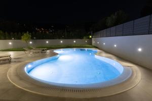 a large swimming pool in a courtyard at night at Infinity Lefkas Villas in Lefkada