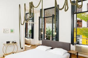 a bedroom with a bed and some windows at B&B DRUUM in Brussels