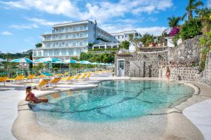 a woman sitting in a pool at a hotel at Hermitage Resort & Thermal Spa in Ischia Town