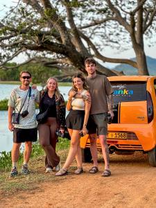 a group of people standing in front of a bus at Nehansa Resort and safari in Tissamaharama