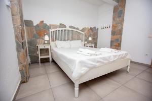 a bedroom with a white bed with towels on it at T H E BERLIN Studios and Suites in Nea Vrasna