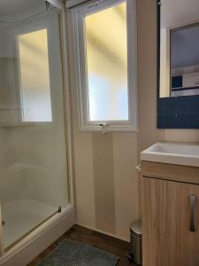 a bathroom with a shower and a sink and a window at camping soleiluna in Herm +39 photos