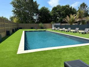 a swimming pool in a yard with chairs and grass at camping soleiluna in Herm