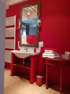 a red bathroom with a sink and a mirror at Maison d'Eusébia in Château-Chalon +53 photos