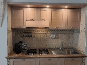 eine Küche mit einer Spüle, einem Herd und Schränken in der Unterkunft Casa Angolo dei Sogni in Martina Franca + 8 Fotos