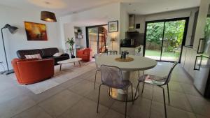 a living room with a table and chairs at "L'Evasion" Maison avec jardin, Climatisation, Parkings privés, à 5mn à pied du centre Ville in Colmar