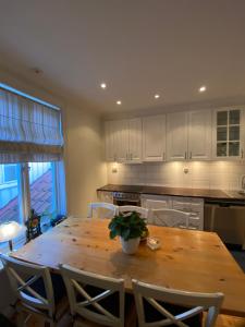 a large kitchen with a wooden table and chairs at Sjarmerende leilighet i hjertet av Risør in Risør