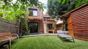 a garden with a bench and a house at "L'Evasion" Maison avec jardin, Climatisation, Parkings privés, à 5mn à pied du centre Ville in Colmar