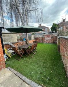 un tavolo e sedie sotto un ombrellone in un cortile di Southampton Bridge Home by AFL a Northampton