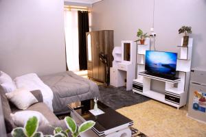 a living room with a couch and a tv at Sweet home in Makerere