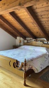 a bedroom with a large bed with a wooden ceiling at Chalet Iris in Bertigo +15 photos