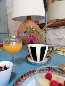 una tavola con piatti di cibo e un bicchiere di succo d'arancia di La Robinière Maison d'Hôtes a Mont-près-Chambord Altre 50 foto