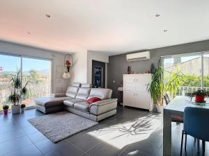 un salon avec un canapé et une table dans l'établissement Campagne en ville Villa T3 75m2 Jardin 60m2, à Auriol