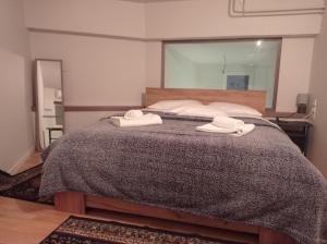 a bedroom with a bed with two towels on it at Ioa Loft in Ioannina