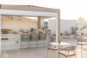 a restaurant with chairs and a counter with tables and chairs at Palazzo Arco Cadura Hotel & Spa in Galatina