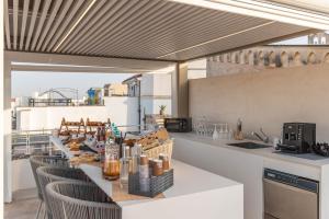 a kitchen with a bar with chairs and a counter top at Palazzo Arco Cadura Hotel & Spa in Galatina
