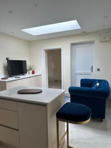 een kamer met een bureau en een blauwe stoel bij CozyCorner - 2 Bed in Egham Heathrow Windsor in Egham +9 foto's