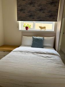 een slaapkamer met een groot wit bed met een raam bij CozyCorner - 2 Bed in Egham Heathrow Windsor in Egham