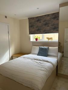 een slaapkamer met een bed met een blauw kussen erop bij CozyCorner - 2 Bed in Egham Heathrow Windsor in Egham