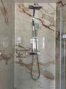 een douche in een badkamer met een douchekop bij CozyCorner - 2 Bed in Egham Heathrow Windsor in Egham