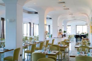 a restaurant with tables and chairs and a piano at Hermitage Resort & Thermal Spa in Ischia Town