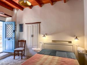 a bedroom with a bed and a chair and a window at Symi Uptown Carmine in Symi