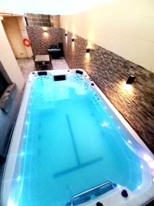 duży basen z błękitną wodą w pokoju w obiekcie Luxurious apartment with heated pool jacuzzi w mieście Fontana