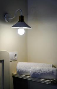 a room with a bed with a light on the wall at Symi Uptown Carmine in Symi
