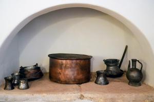 a shelf with a pot and some vases on it at Symi Uptown Carmine in Symi