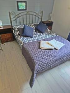 a bed with blue pillows on it in a bedroom at Pokoje gościnne Cuma in Łeba