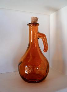 an orange bottle with a cork sitting on a table at Symi Uptown Carmine in Symi
