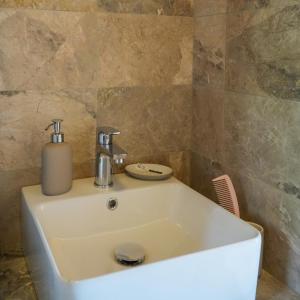 a bathroom sink with a soap dispenser on top of it at Symi Uptown Carmine in Symi