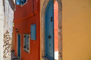an orange and blue building with a blue door at Symi Uptown Carmine in Symi