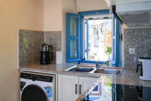a kitchen with a sink and a washing machine at Symi Uptown Carmine in Symi